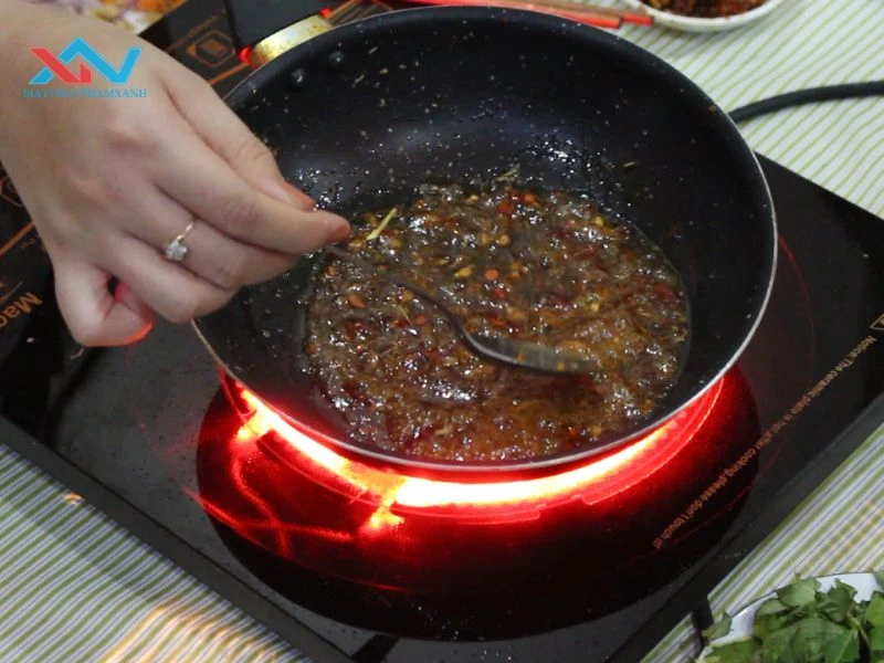 Cho tương ớt, đường, nước mắm vào chảo, đun nhỏ lửa.